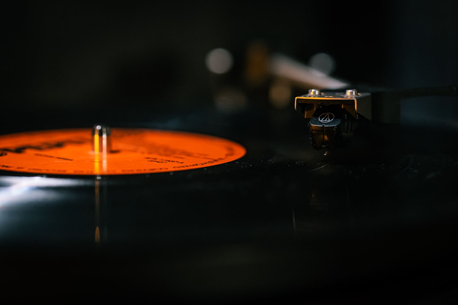 Detailed still life of a turntable needle on a spinning vinyl record, capturing the analog music experience.
