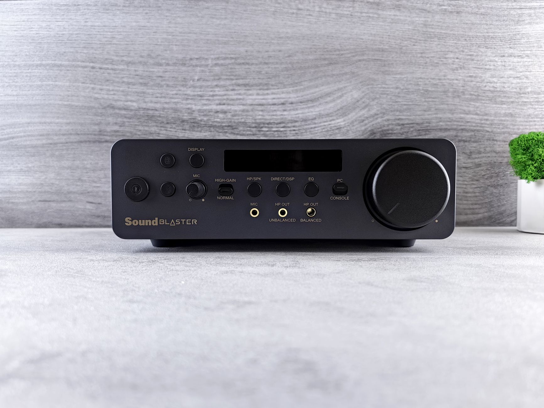 Front view of a sleek audio amplifier with various input and control buttons.