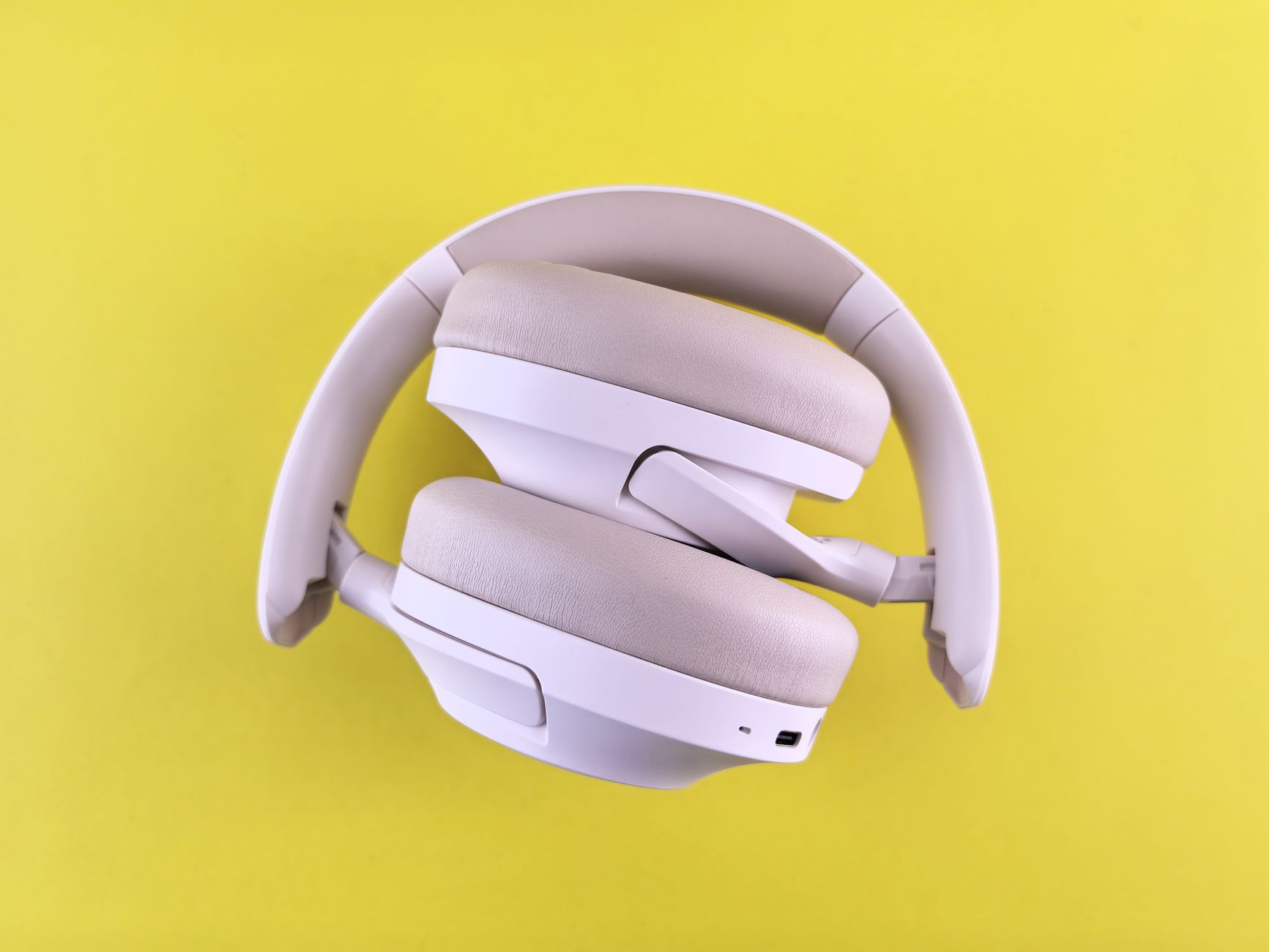 Stylish over-ear headphones in white against a vivid yellow backdrop. Ideal for tech lifestyle imagery.