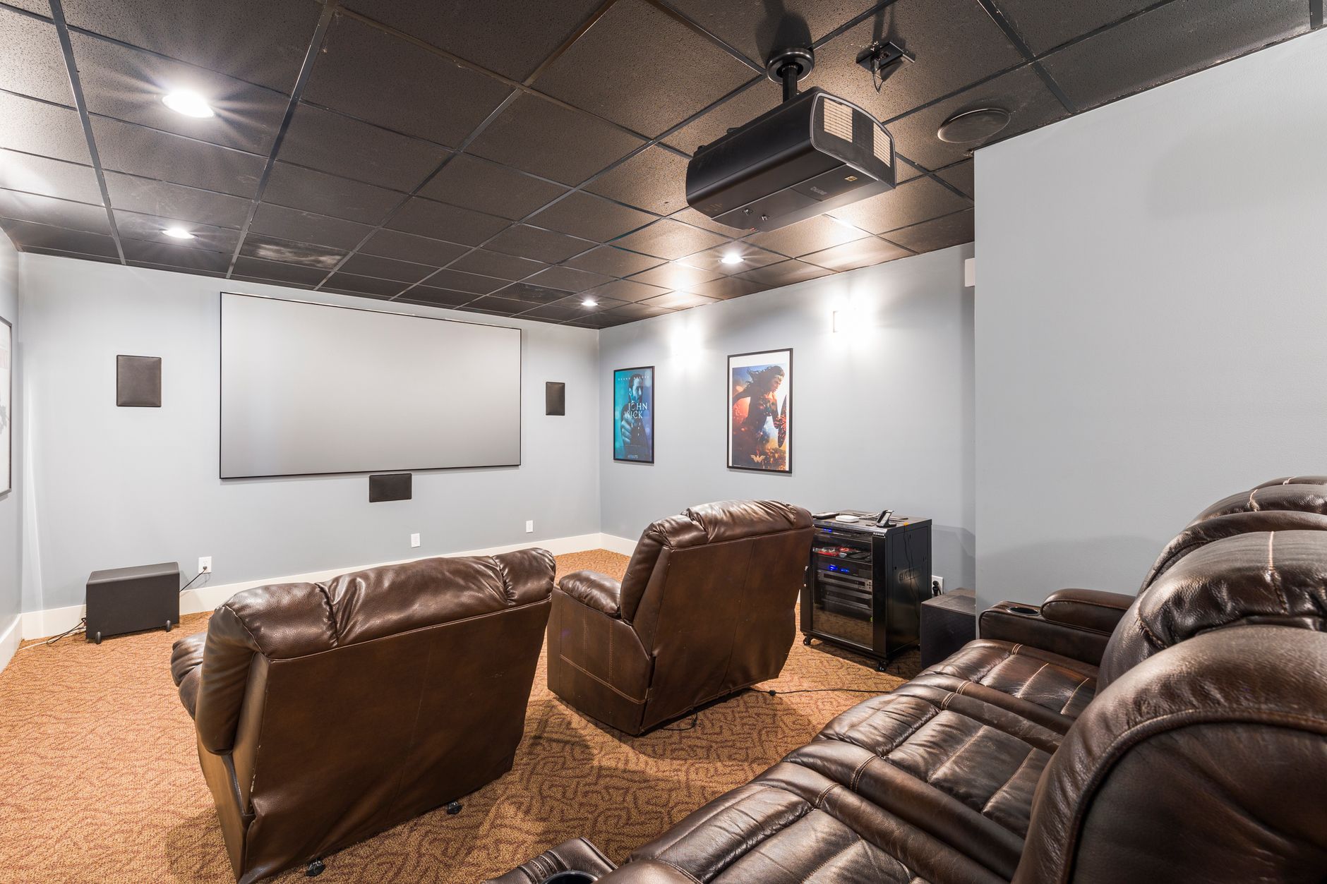 Cozy home theater setup with plush leather recliners and modern audiovisual equipment.