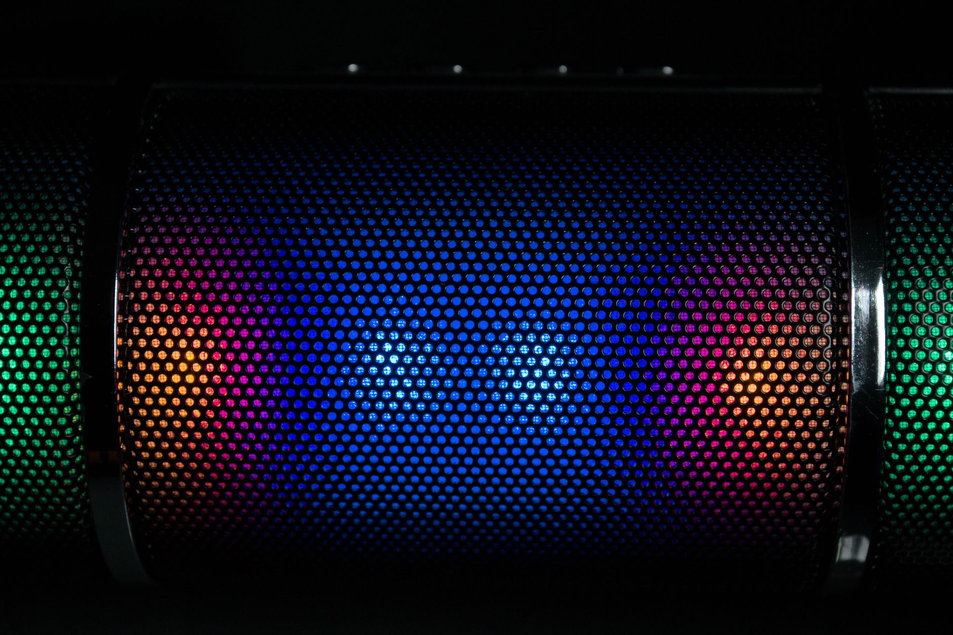 Vibrant LED lights illuminate a speaker grille with colorful patterns.