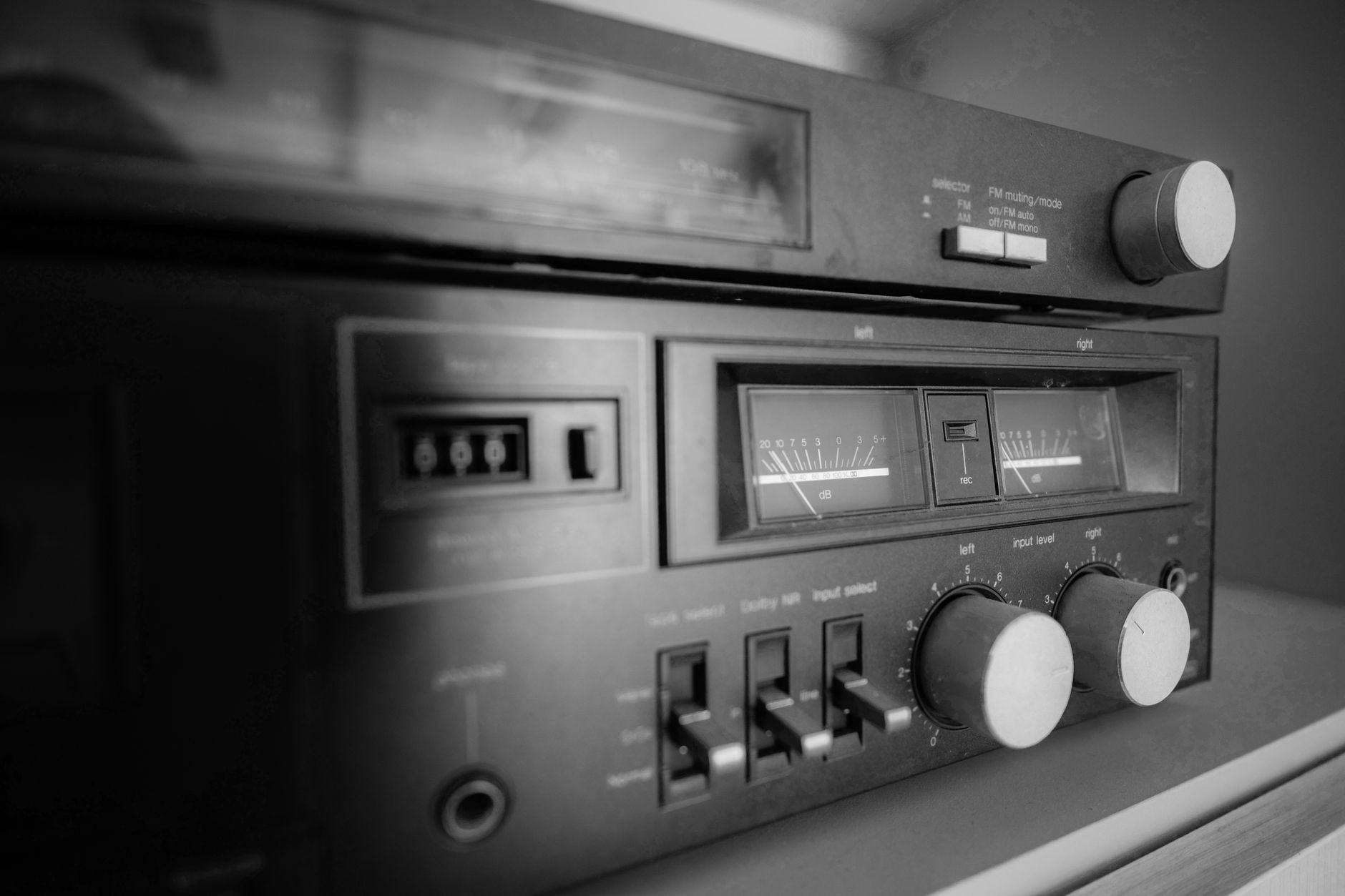 Close-up of classic stereo equipment featuring knobs and dials, captured in black and white.