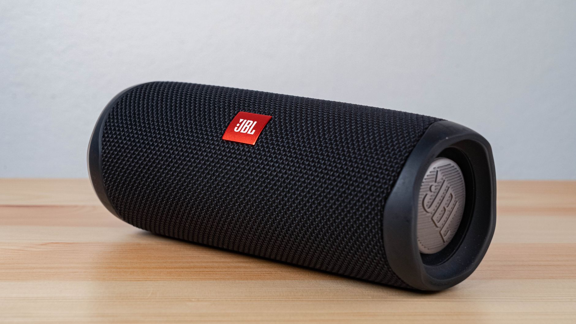 Close-up of a modern wireless speaker on a wooden table, highlighting sleek design.