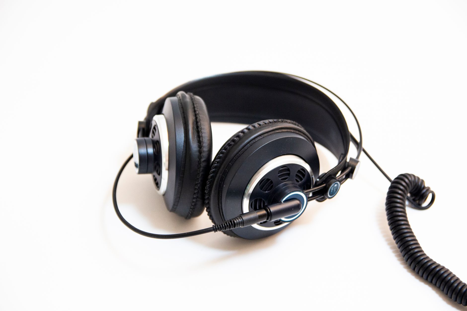 Studio-quality black headphones with coiled cable on a clean white background.
