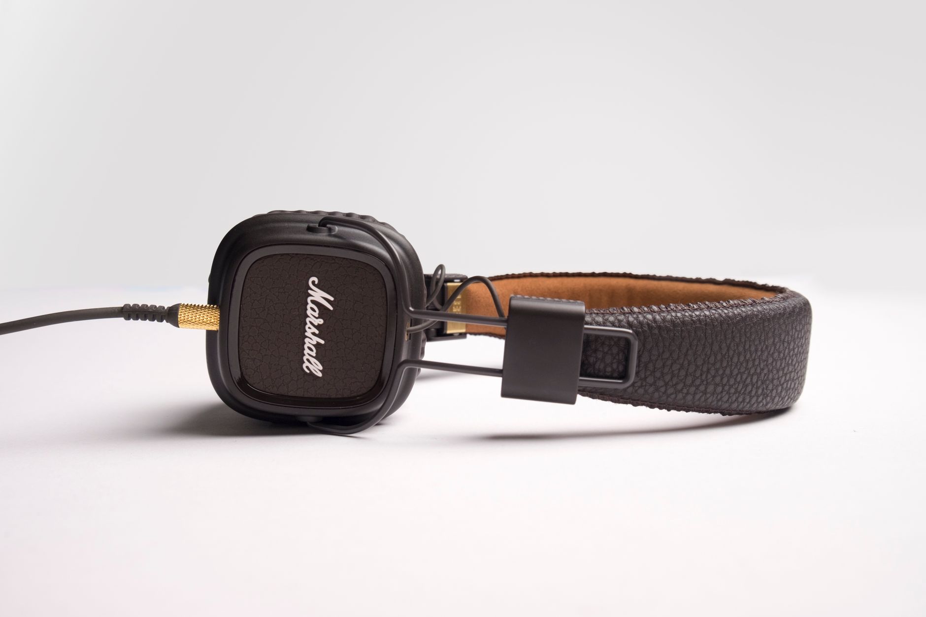 Stylish black over-ear headphones featuring a cushioned headband and branded earcups on a white background.