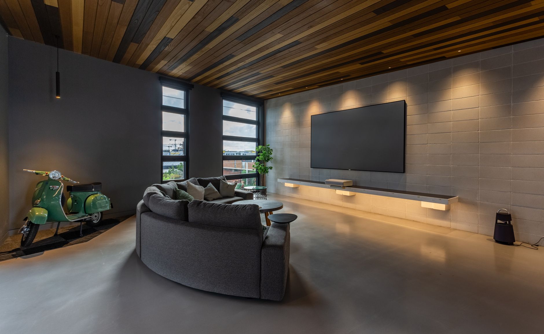 Stylish modern living room featuring sleek furniture and a large screen TV.